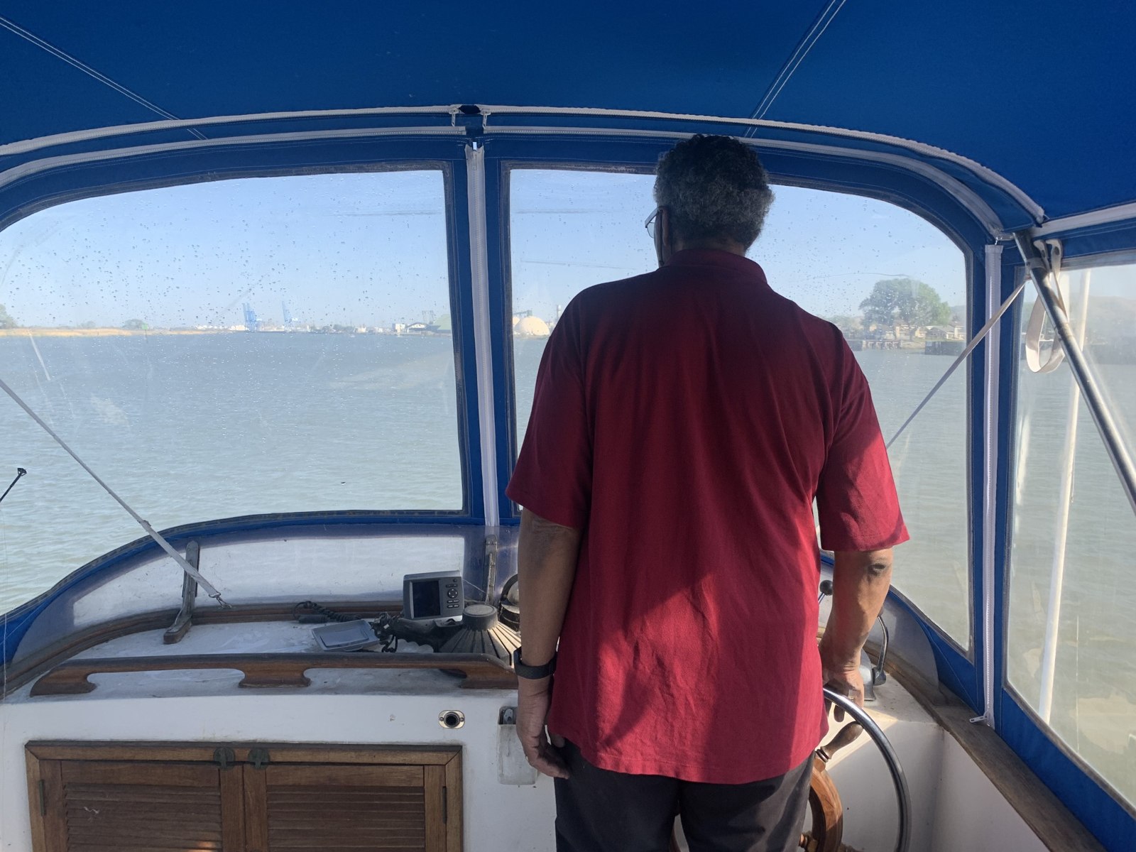 Original photo of a captain at the helm, facing the water